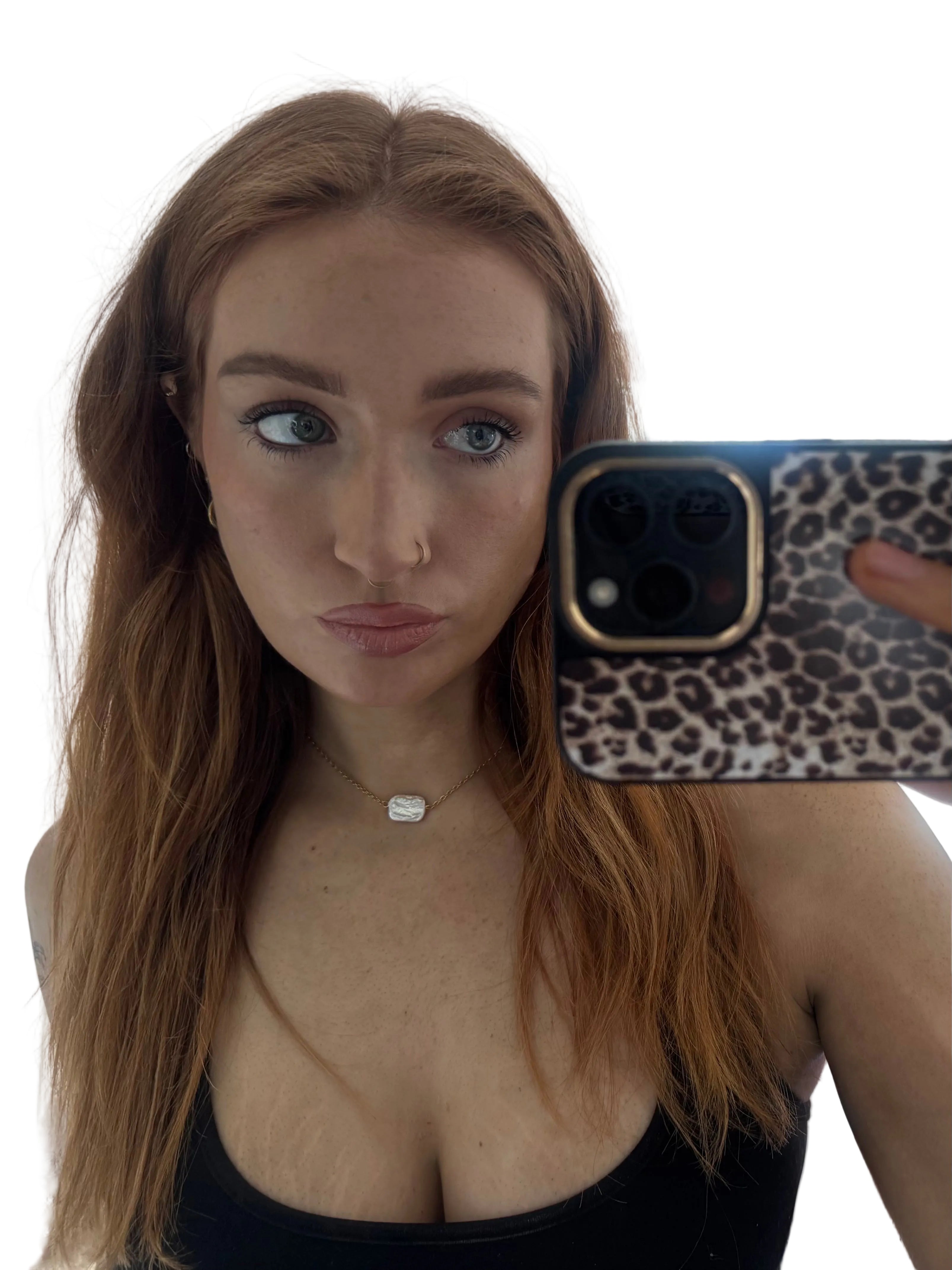 Person holding a phone with a leopard print case, taking a mirror selfie.