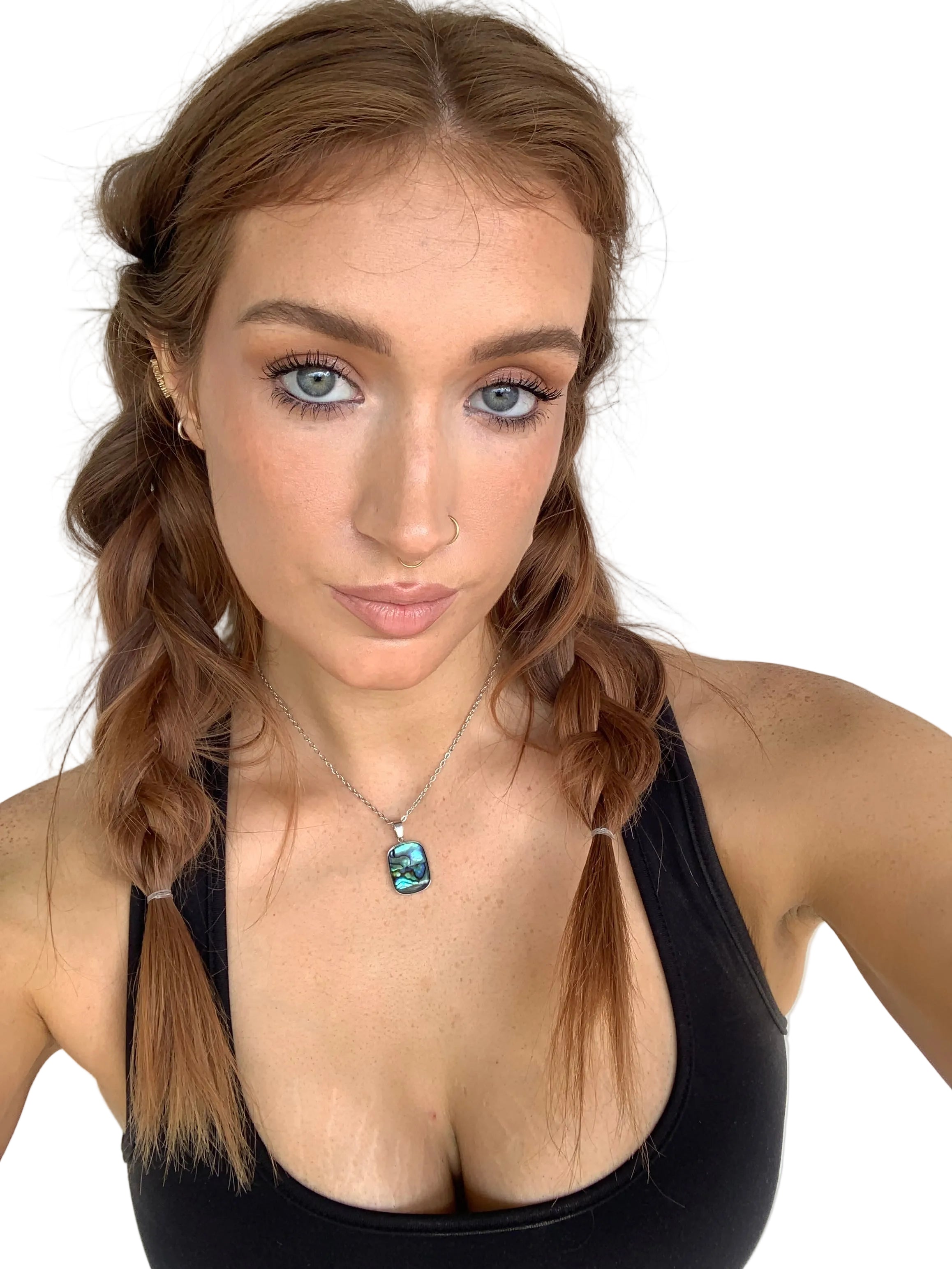 Woman with braided hair wearing a necklace with an abalone pendant on a white background