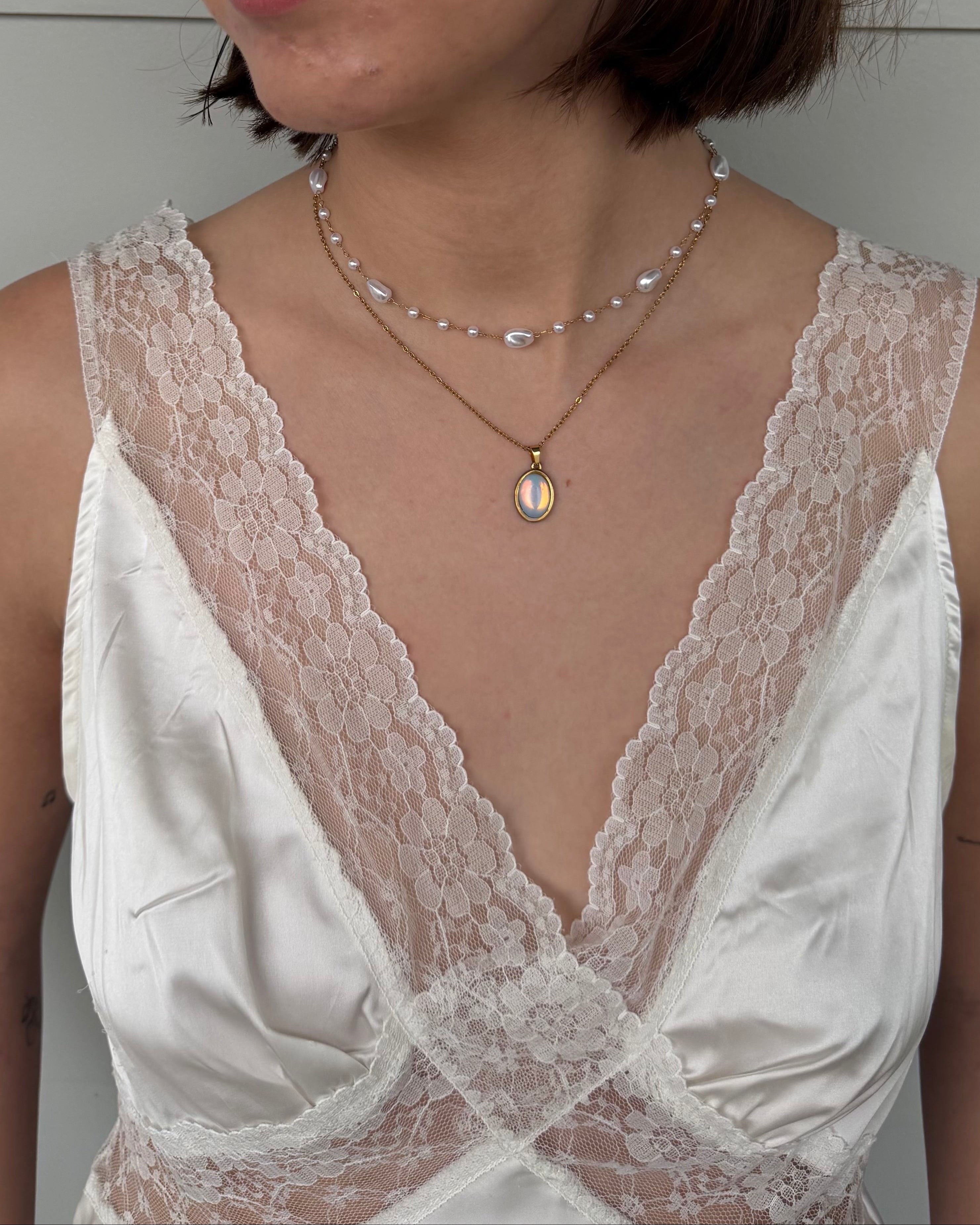 White lace dress with a necklace worn by a person
