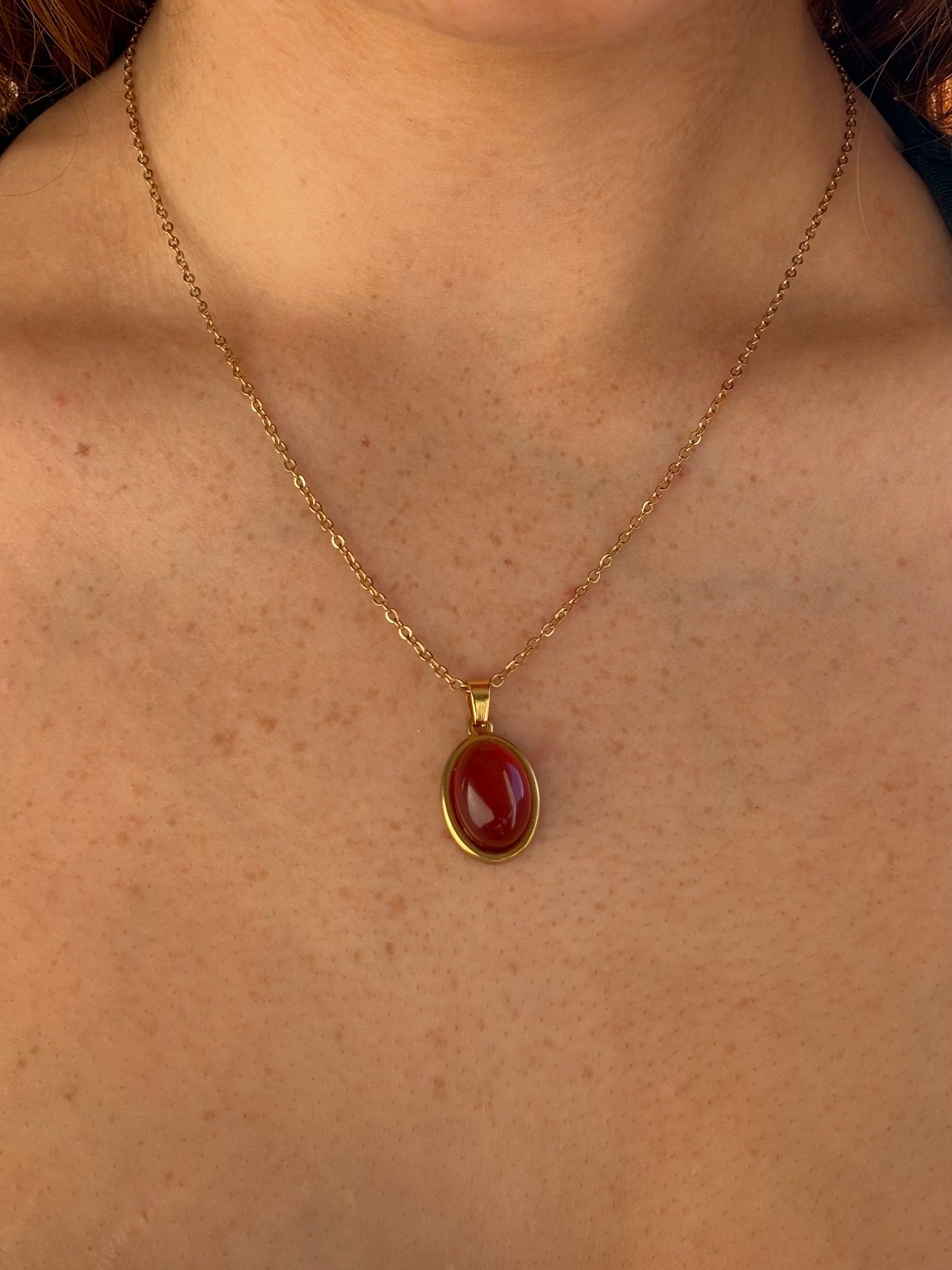 Necklace with a red pendant worn by a person