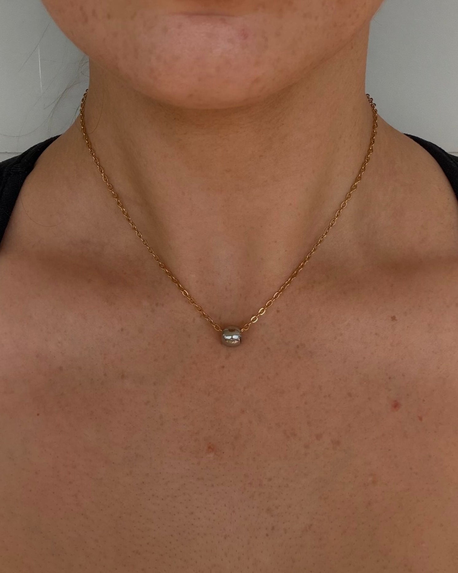 two toned stainless steel necklace. silver ball pendant